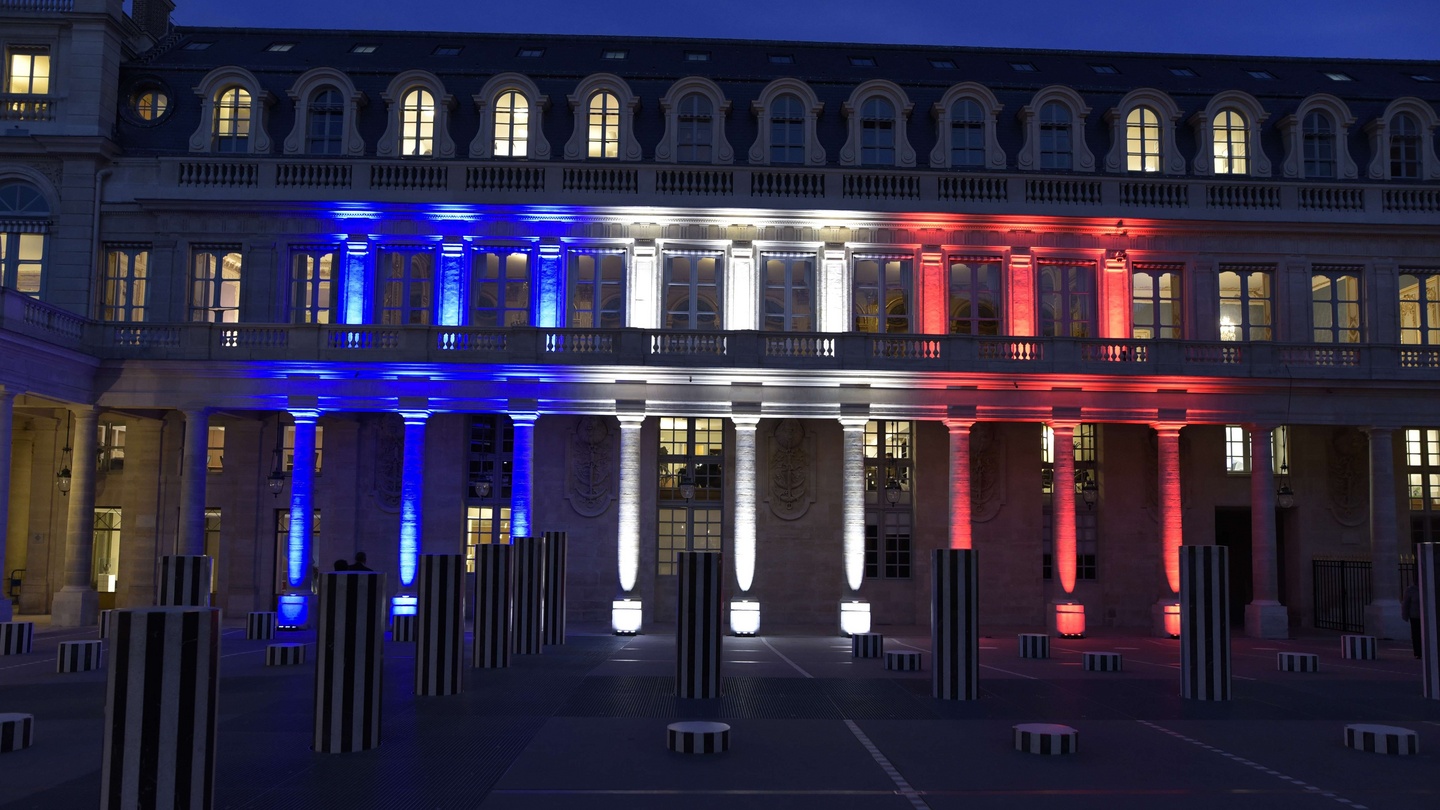 Le drapeau français illuminant la façade du Ministère de la Culture au Palais Royal à Paris