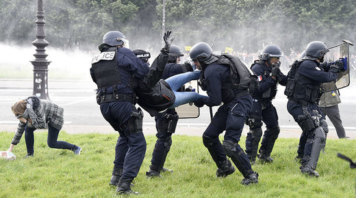 Police officers detain a demonstrator during clashes near the Invalides during a protest against proposed labour reforms in Paris on June 14, 2016