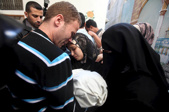BBC Arabic picture editor Jihad Misharawi and his wife mourn during the funeral of their 11-month-old baby boy Omar, who was killed the previous day when an Israeli shell hit their Gaza City home, 15 November