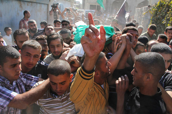 Mourners carry the body of a fighter killed in an Israeli airstrike during his funeral in the Gaza Strip town of Khan Yunis, 28 October