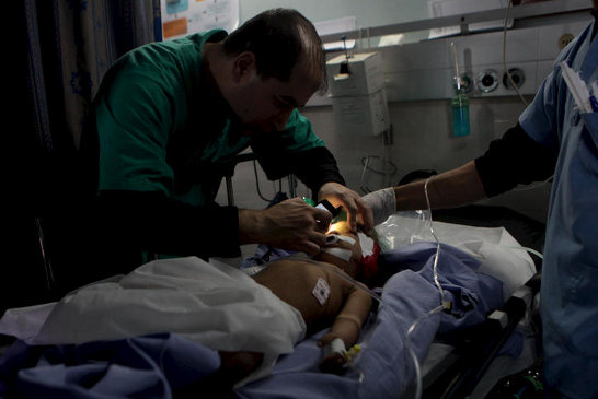 A doctor at Gaza City’s al-Shifa hospital uses the light of his mobile phone to check the vital signs of critically-injured Haneen Tafish, a one-year-old from the al-Zeitoun neighborhood on 15 November, the second day of a massive Israeli attack on Gaz