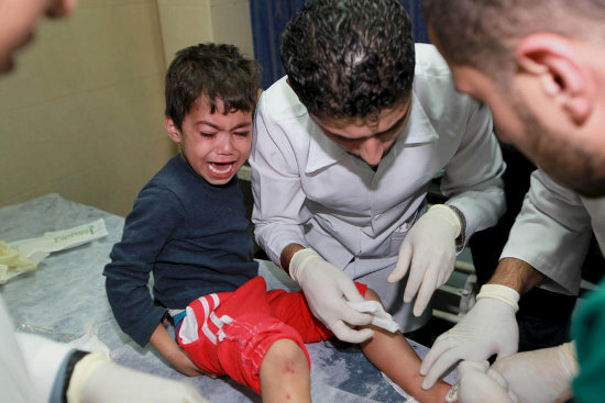 A Palestinian medic treats a wounded boy at Gaza City’s al-Shifa hospital following an Israeli airstrike, 14 November
