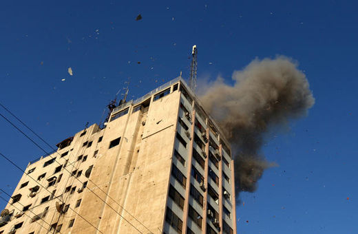 Smoke rises as an Israeli air strike hits a media center in Gaza, 18 November.
