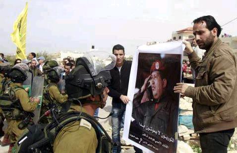 Mars 2013. Des citoyens palestiniens déploient un portrait de Hugo Chavez face aux troupes d’occupation du gouvernement israélien.