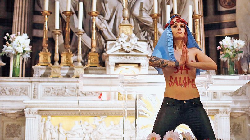 Une jeune femme, membre du collectif féministe Femen, au cours d'une action devant l'autel de l'église de la Madeleine à Paris, le 20 décembre
