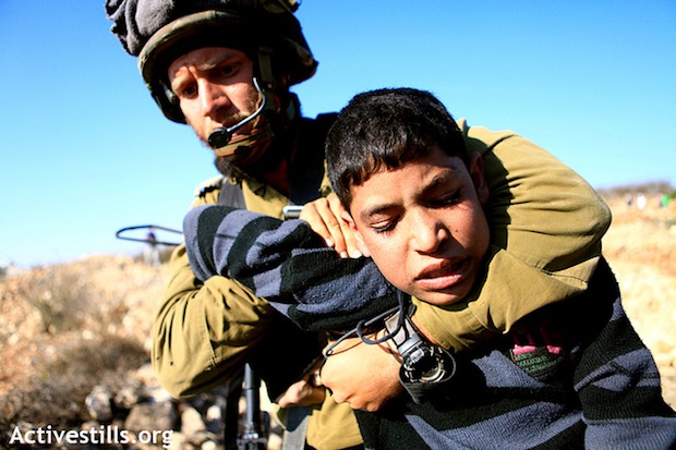 Soldat israélien immobilisant un jeune Palestinien