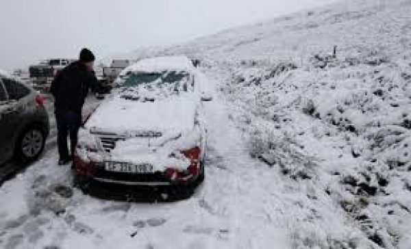 A motorist removes the snow from his car on the Swaarmoed Pass, 10 km outside Ceres in Western Province Cape, South Africa, on July 3, 2018.