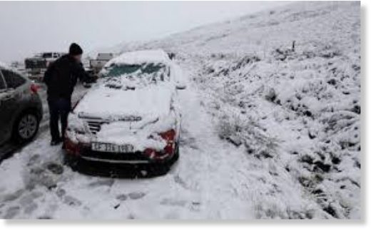 Cliquer pour agrandir A motorist removes the snow from his car on the Swaarmoed Pass, 10 km outside Ceres in Western Province Cape, South Africa, on July 3, 2018.
