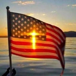 Le coucher de soleil dessinant en filigrane la Croix chrétienne derrière le drapeau des Etats-Unis