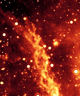 Filaments de courant torsadés dans la nébuleuse de la Double Hélice, près du centre de la Voie lactée, en lumière infrarouge.