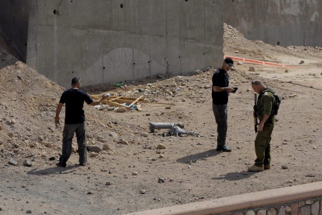 Des enquêteurs examinent la scène où une roquette se serait abattue mercredi dans la ville israélienne d'Eilat.