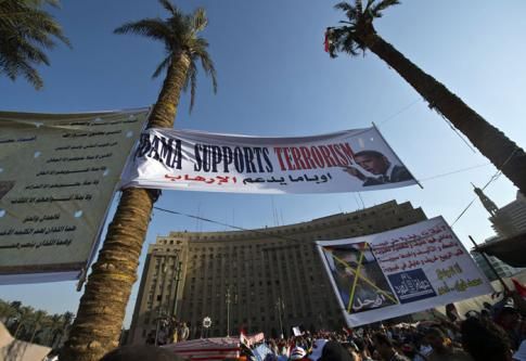 Des manifestants défilent sous une bannière accusant Barack Obama de soutenir le terrorisme, 30.06.2013