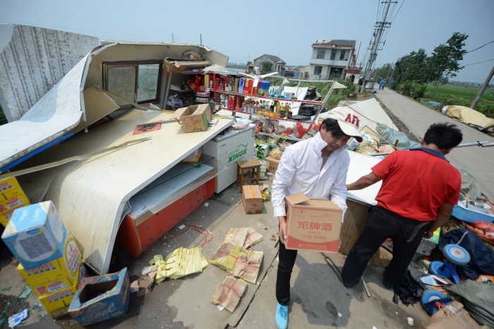 China tornades, Des personnes récupèrent les marchandises d’un magasin effondré, à la suite du passage d’une tornade dans le village de Yuhu de la ville de Gaoyou, dans la province orientale du Jiangsu, le 8 juillet 2013